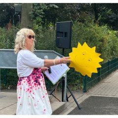 Woman distributes suns made of clay cardboard.