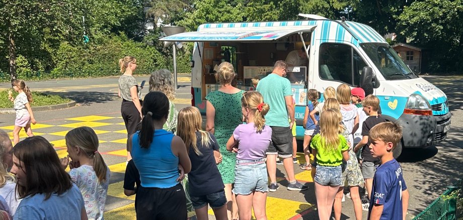 Children queue in front of the ice cream truck