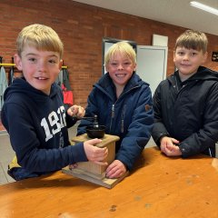 The children grind flour from wheat grains.