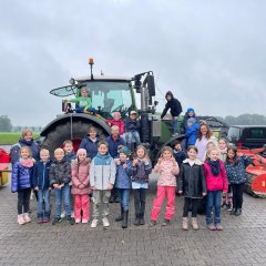 Group photo of class 2a in front of a tractor.