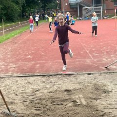 Child jumps into the sand pit.