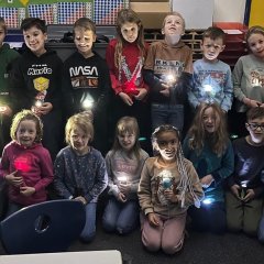 Second grade children with flashlights.