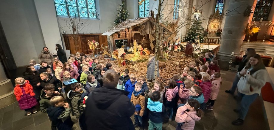 Children stand in front of the crib.