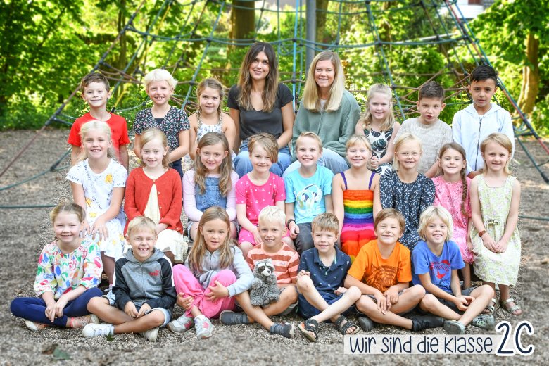 Children of the raccoon class with their class teacher and the class animal