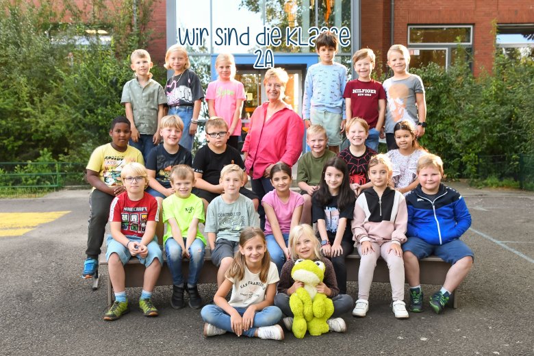 Children of the frog class with their class teacher and the class animal.