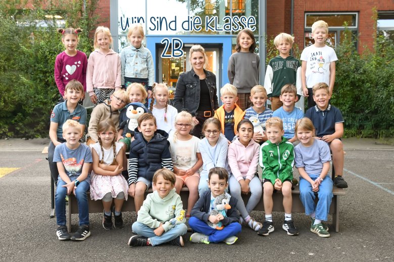 Children of the penguin class with their class teacher and the class animal