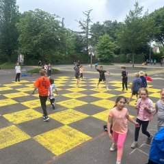 Los niños pasan el tiempo de espera con juegos en el gran patio de recreo.