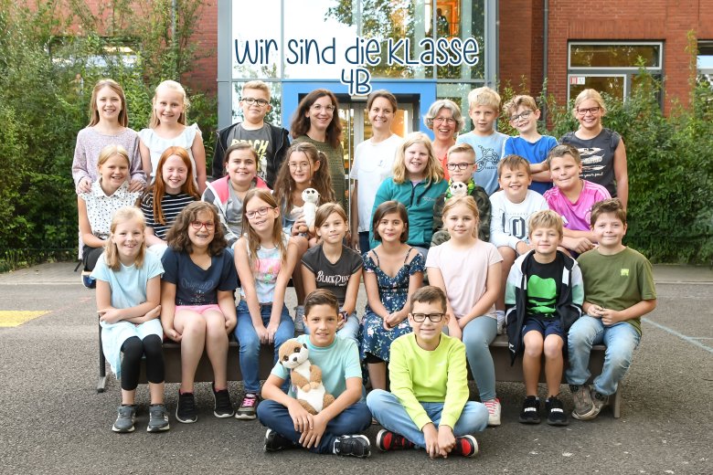 Los niños de la clase de suricatas con su profesor y la familia de animales de la clase