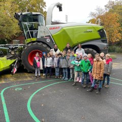 Photo de groupe de la classe 2a devant l'ensileuse à maïs.