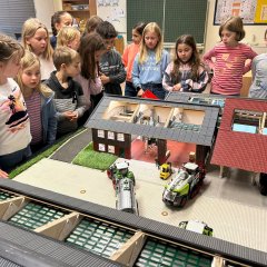 Les enfants de la classe 4b observent la maquette d'une entreprise de travaux agricoles.