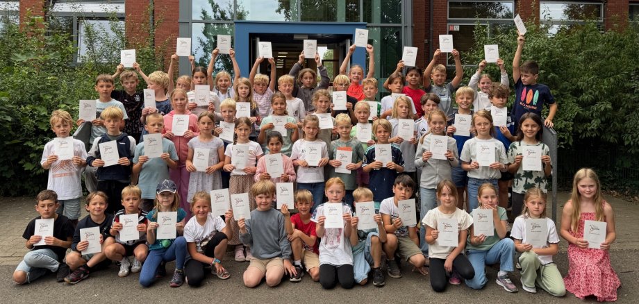 Les enfants montrent fièrement leurs certificats d'honneur.