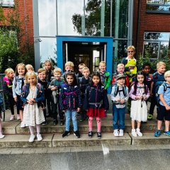 I bambini della prima classe (1a) con la loro insegnante di classe davanti all'ingresso principale della Scuola Georg.