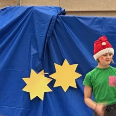 背景の前でノームと月を演じる子供たち。
