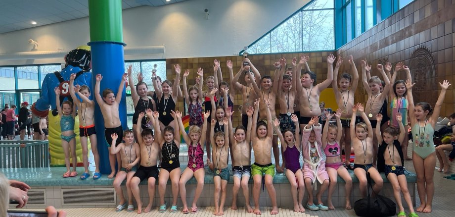 Barna gleder seg over suksessen i svømmekonkurransen.
