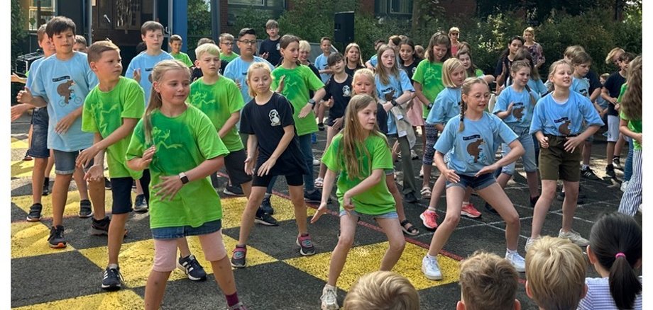 Jongens en meisjes van de afstudeerklassen dansen.