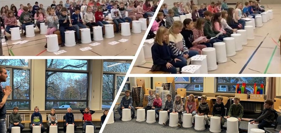 Kinderen zitten achter hun trommels en luisteren naar de uitleg van meneer Bruns.