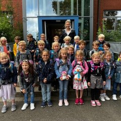 De kinderen van de eerste klas (1b) met hun klassenleraar voor de hoofdingang van de Georg School.