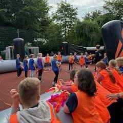 Twee teams spelen tegen elkaar aan de menselijke tafelvoetbaltafel.