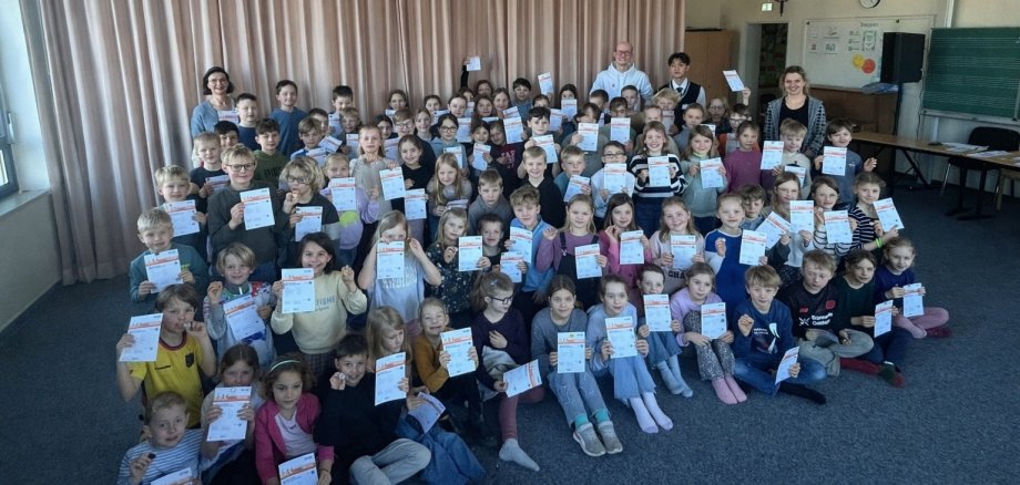 Kinderen laten trots hun sportbadges zien.