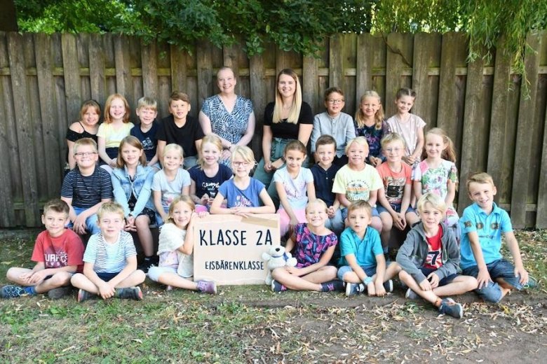 Kinderen met hun klassenleerkracht, de leerkracht in opleiding en het klassendier