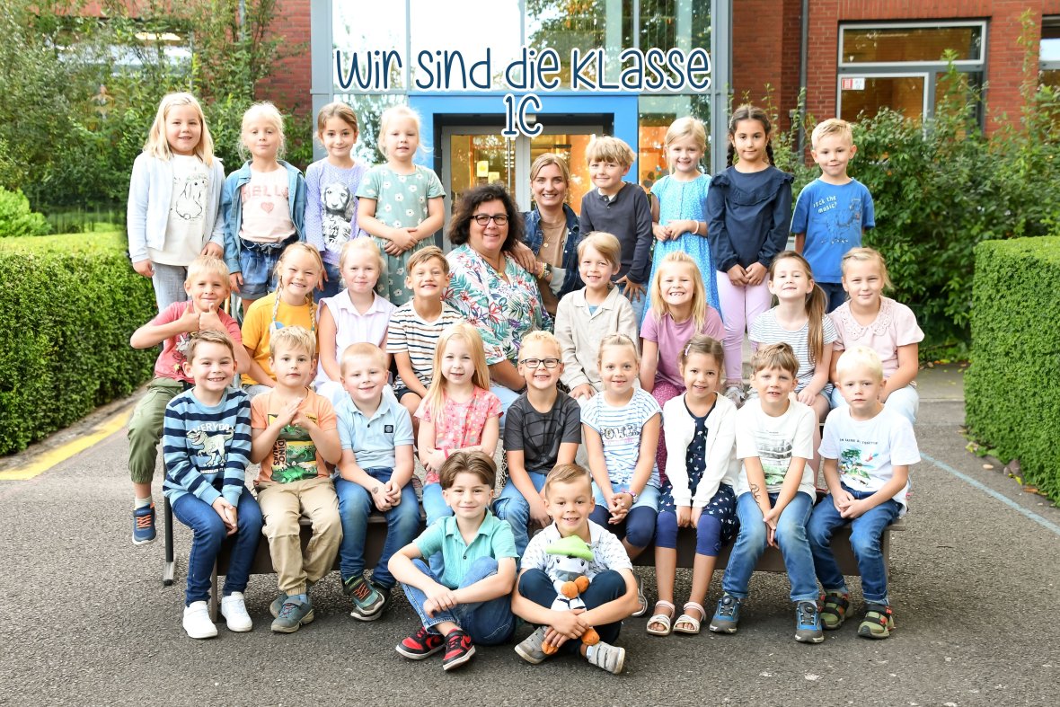 Kinderen van de zebraklas met hun klassenleraar en het dier van de klas