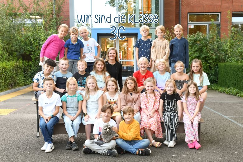 Kinderen van de wasberenklas met hun klassenleraar en het dier van de klas