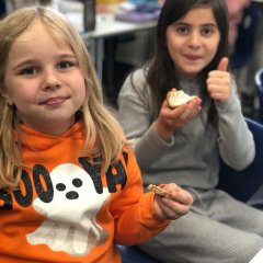 Dzieci w klasie próbują kanapek z domowym masłem.