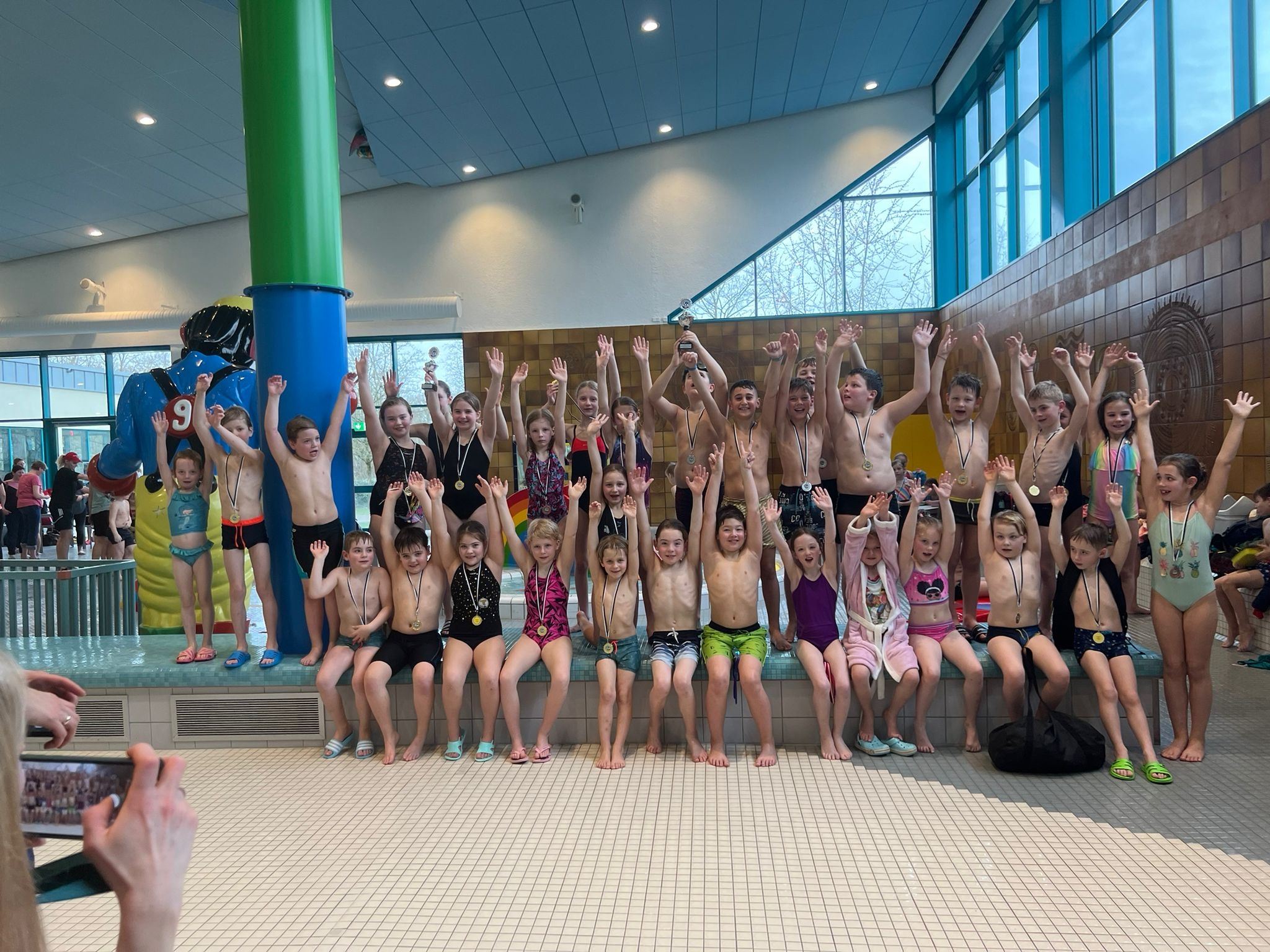 As crianças estão muito contentes com o seu sucesso na competição de natação.