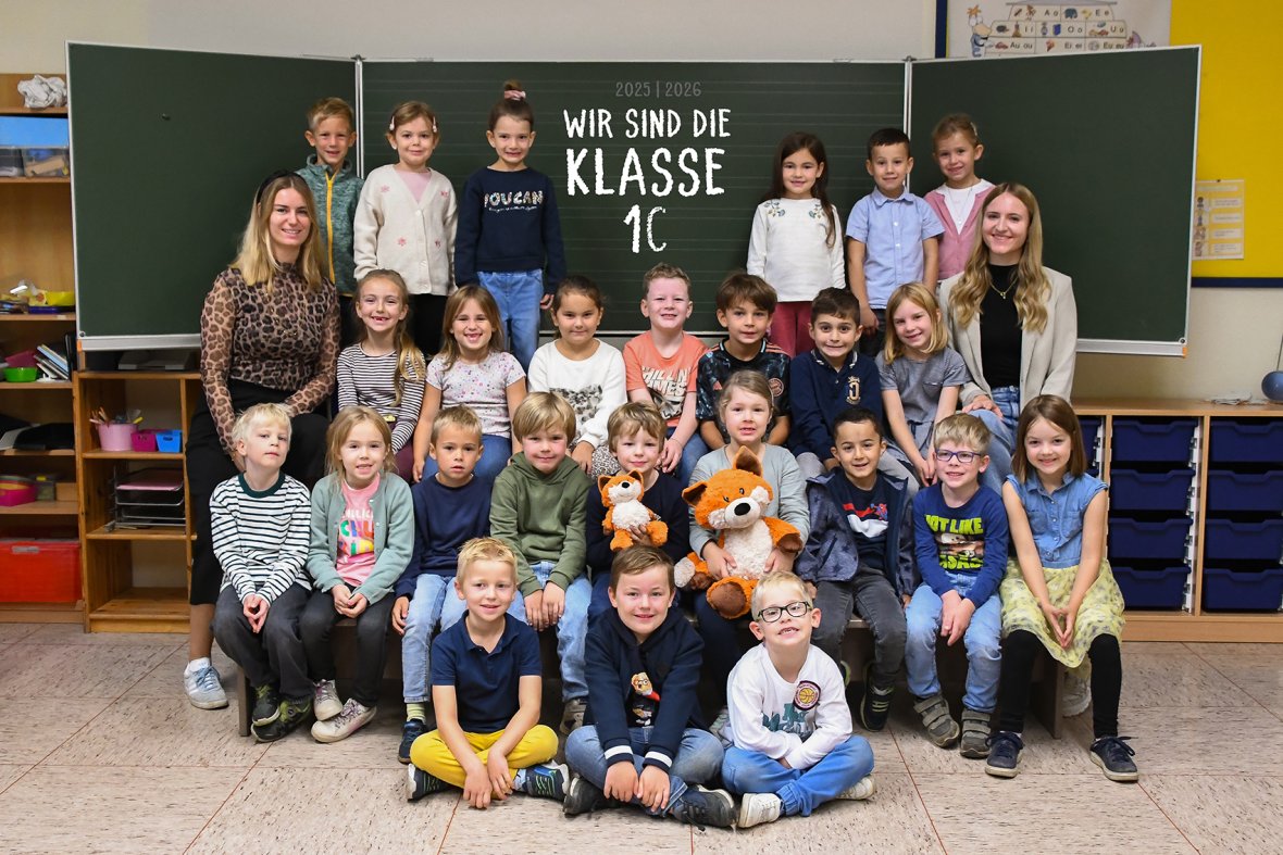 Deti v triede líšok so svojím triednym učiteľom a učiteľom stážistom.